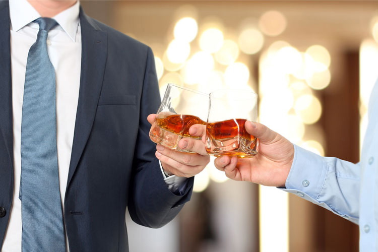 2 Gläser anstoßen mit Whiskey